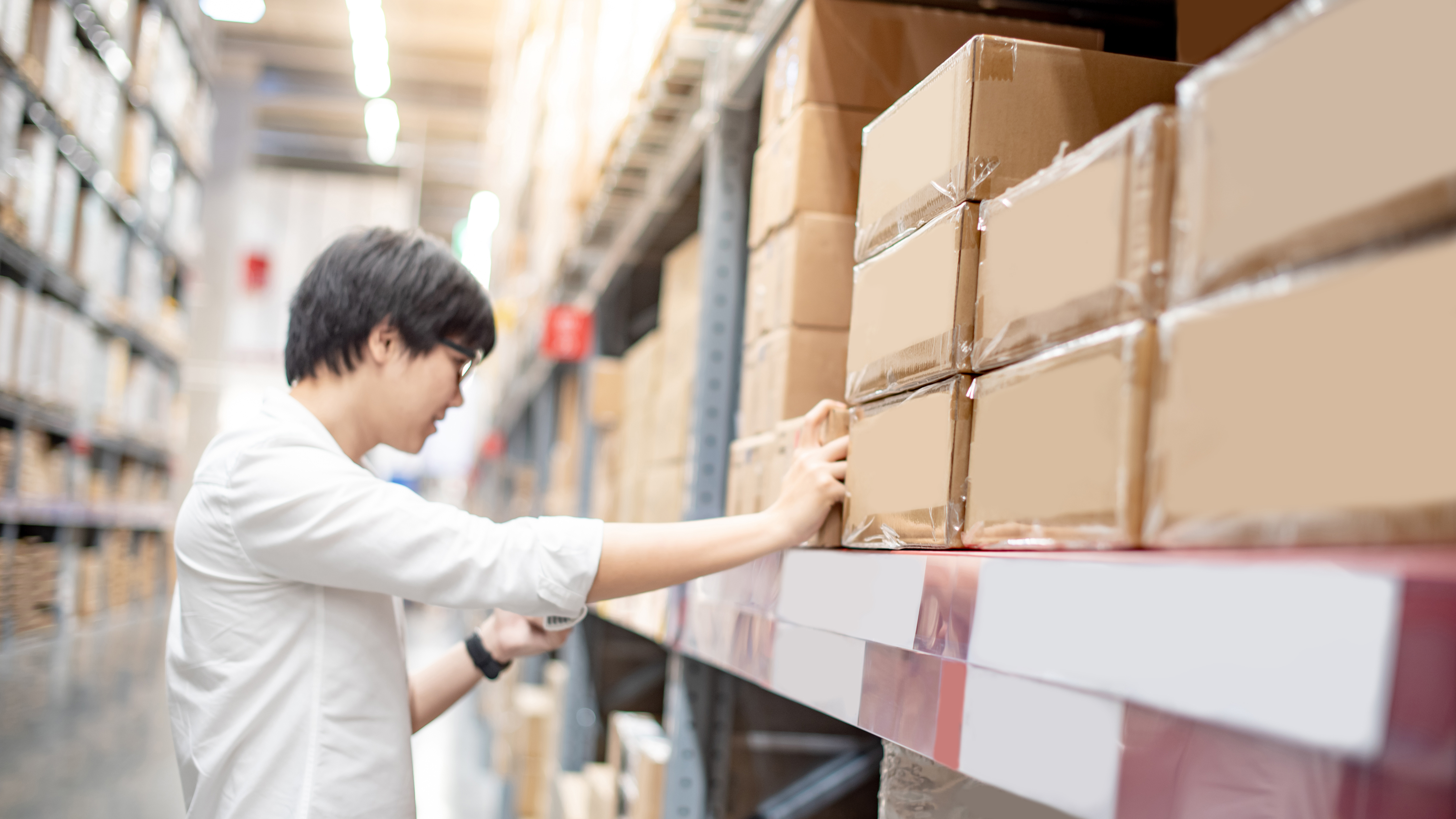 a man checking different boxes in a warehouse