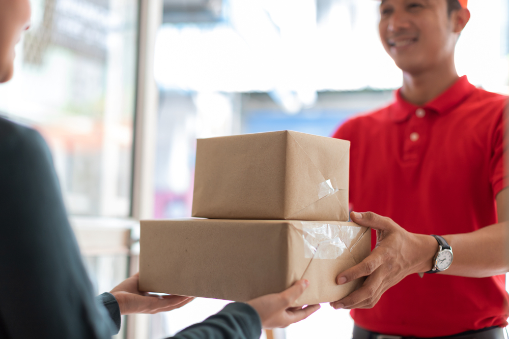 Woman,Accepting,Parcel,From,Hands,Delivery,Man,In,Red,Shirt